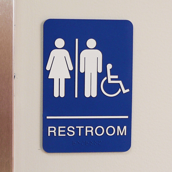 ADA compliant restroom sign with raised tactile letters and braille for restaurant accessibility
