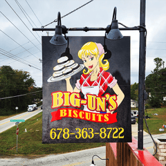 Big Uns Biscuits post and panel sign with colorful graphics displaying logo and phone number