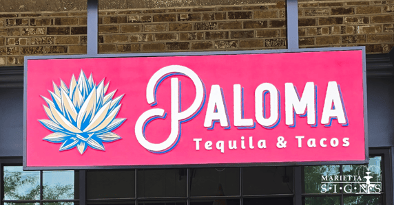 Exterior storefront sign for Paloma Tequila & Tacos installed by Marietta Signs in Marietta, Georgia. Bold pink sign with blue lotus logo and custom lettering improves restaurant visibility in Metro Atlanta.
