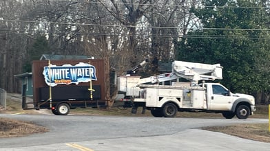 White Water Express monument sign installation in progress with bucket truck and service vehicle in Atlanta Georgia