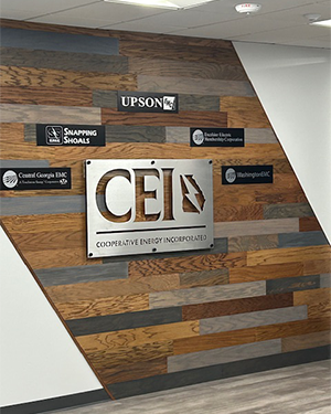 Custom interior lobby wall sign for Cooperative Energy Incorporated (CEI) featuring brushed metal logo and partner EMC plaques, **designed and installed by Signs & More, Inc. in Metro Atlanta, Georgia.